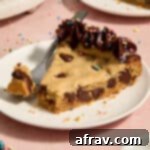 Slice of almond flour peanut butter chocolate chip cookie cake served on a plate with a forkful removed.