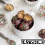 Crispy Peanut Butter Balls in a white mug on a white surface next to jars of sprinkles.