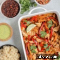 Sheet Pan Fajitas 8 oven baked fajitas in a white baking dish with fajita ingredients in separate bowls around fajita bake