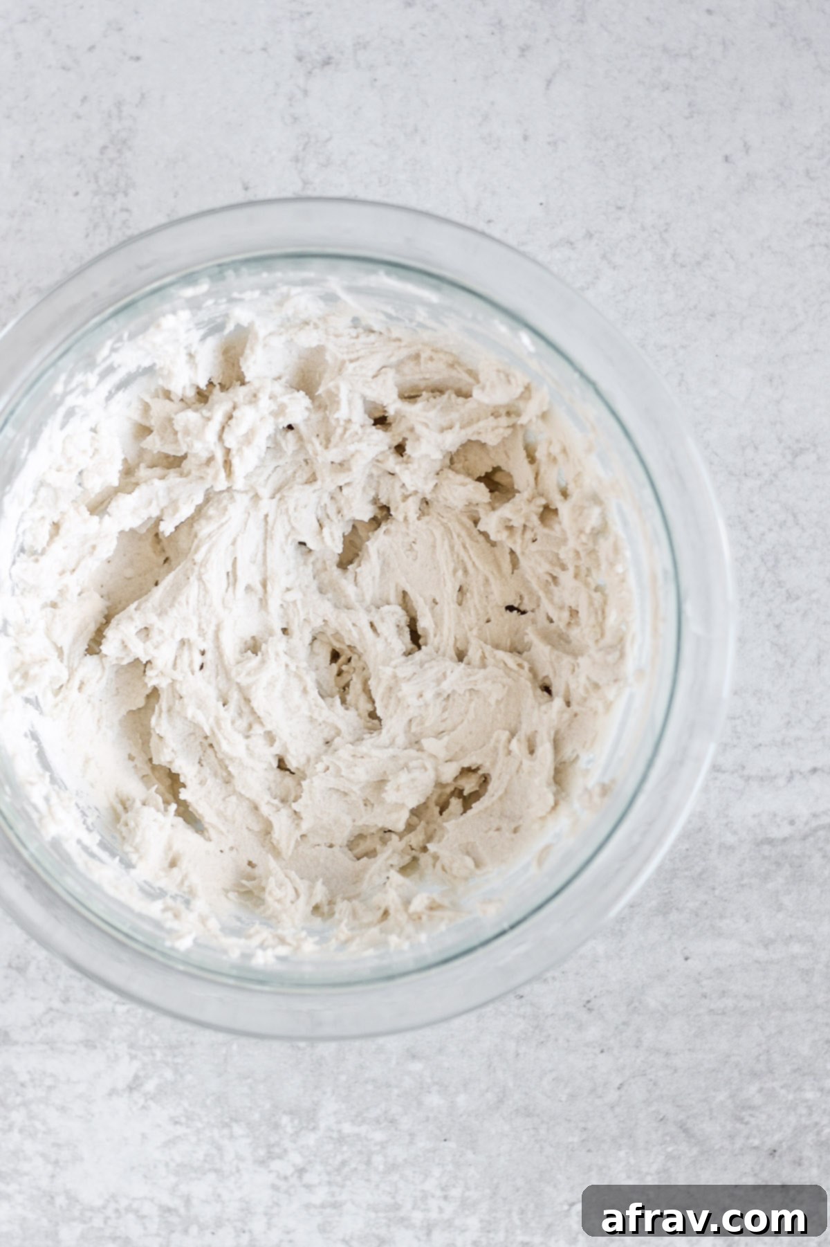 Coconut whipped cream in a glass mixing bowl, looking rich and ready to be served.
