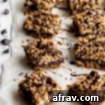 Chocolate Oat Bars topped with chocolate and arranged on parchment paper, a delightful vegan and gluten-free treat.