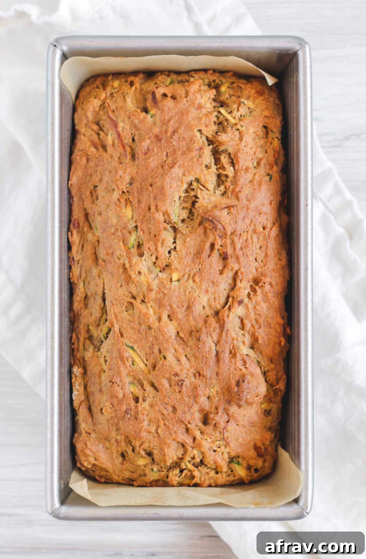 Cooked gluten-free zucchini bread in the loaf pan, golden brown and puffed.
