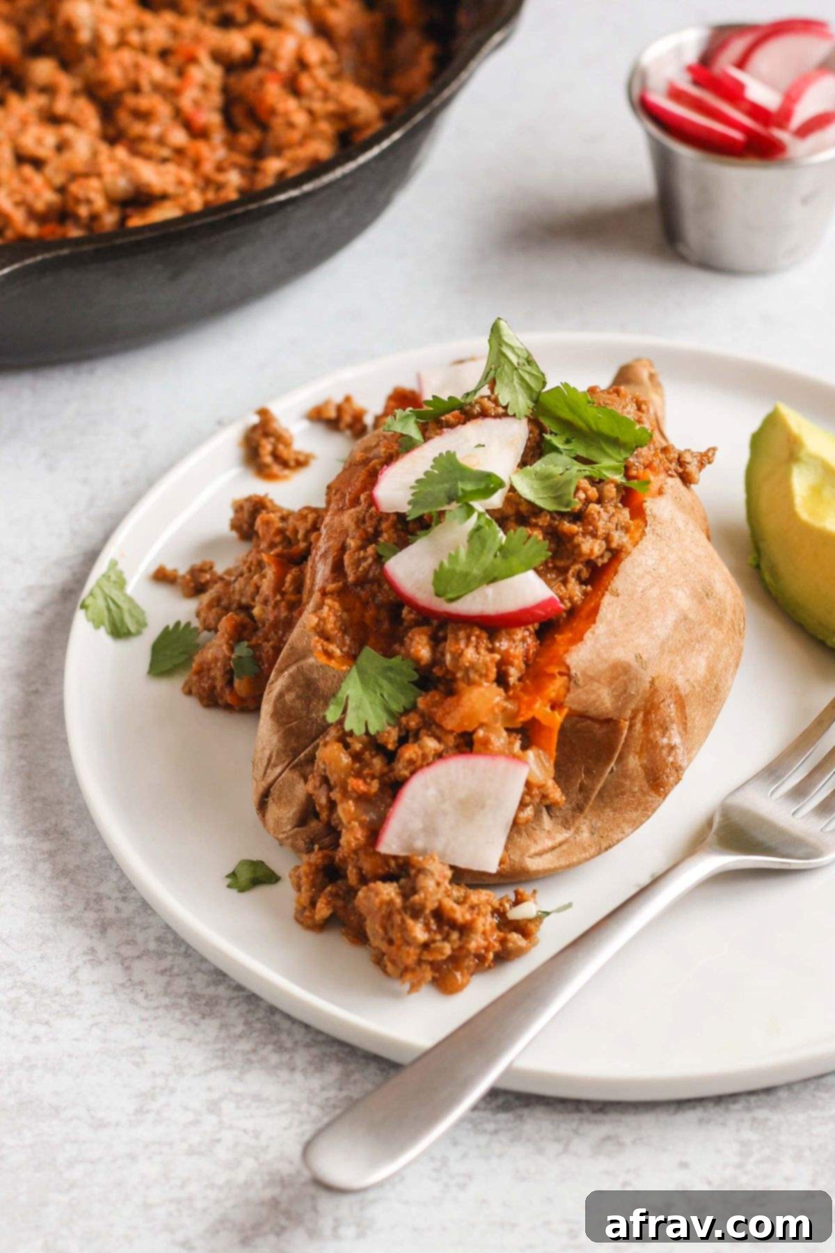 Sweet potato stuffed with chili and topped with radishes and fresh cilantro.