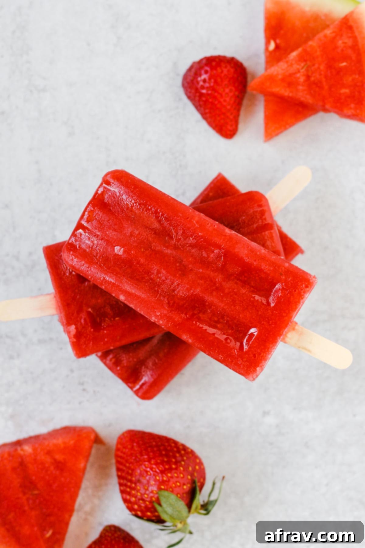 Simple 2-Ingredient Strawberry Watermelon Popsicles 2 stacked popsicles with watermelon slices and strawberries