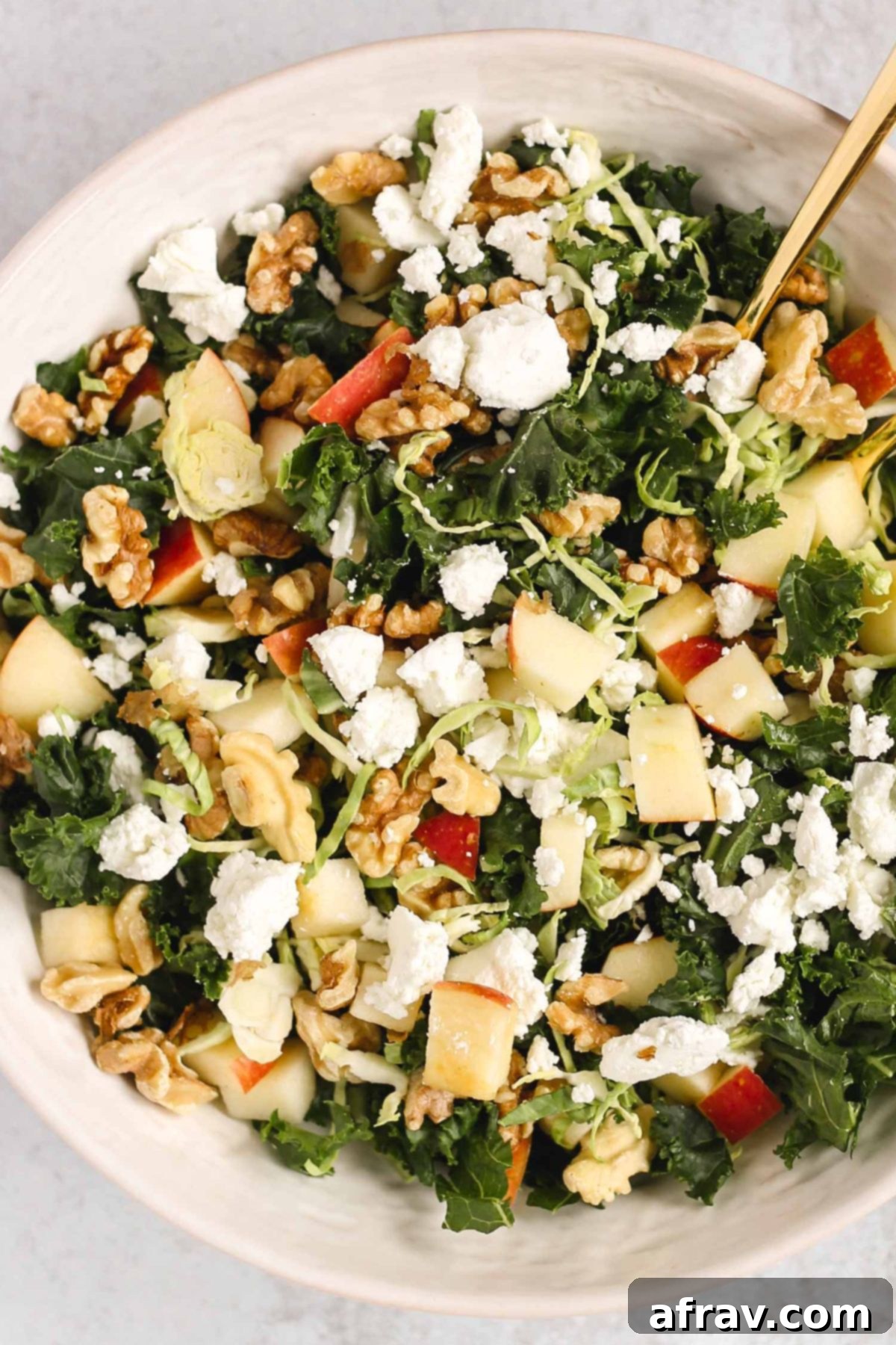 Kale and Brussels sprouts salad assembled in a large serving bowl.