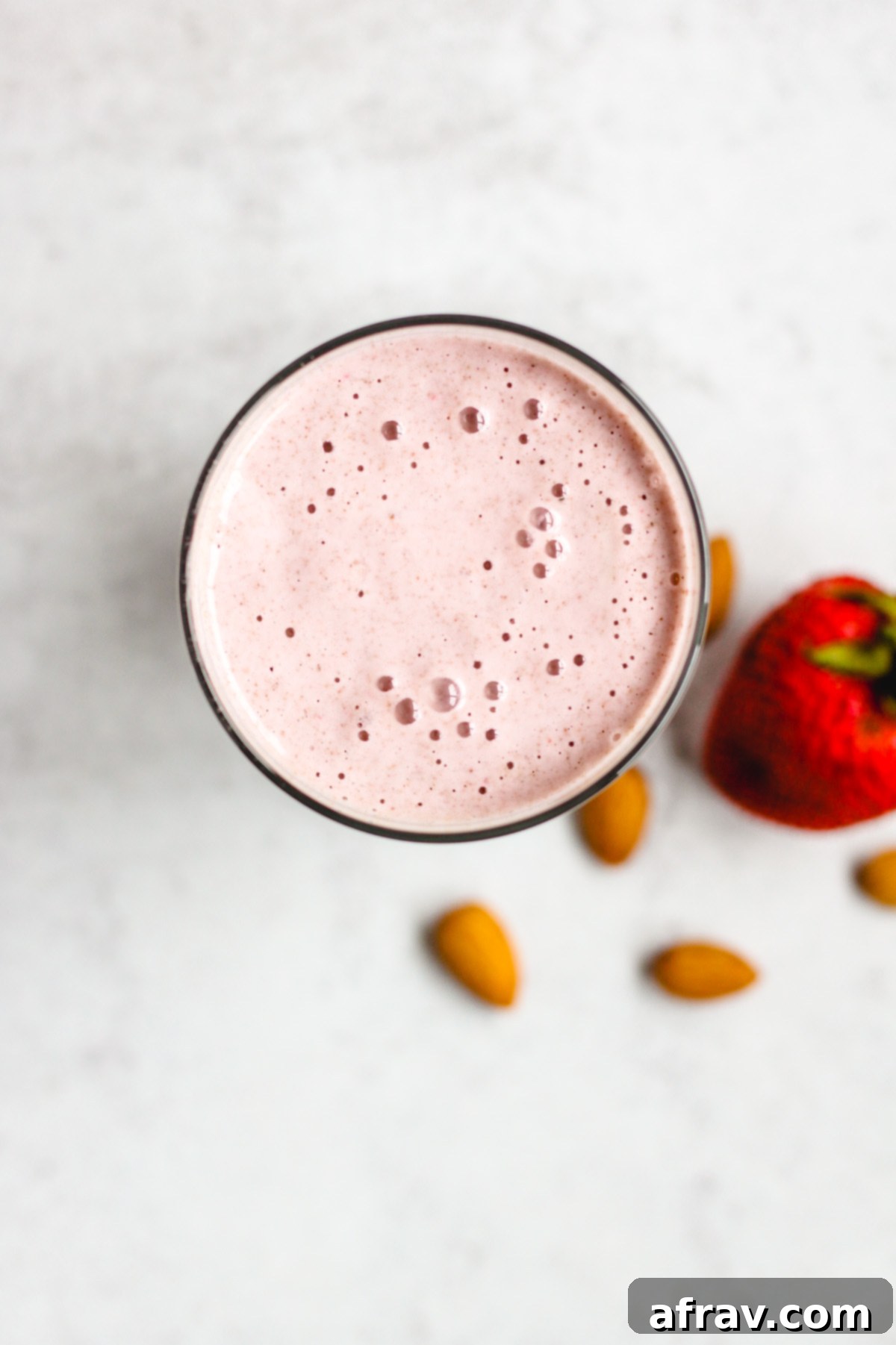 overhead view of strawberry almond smoothie in a glass