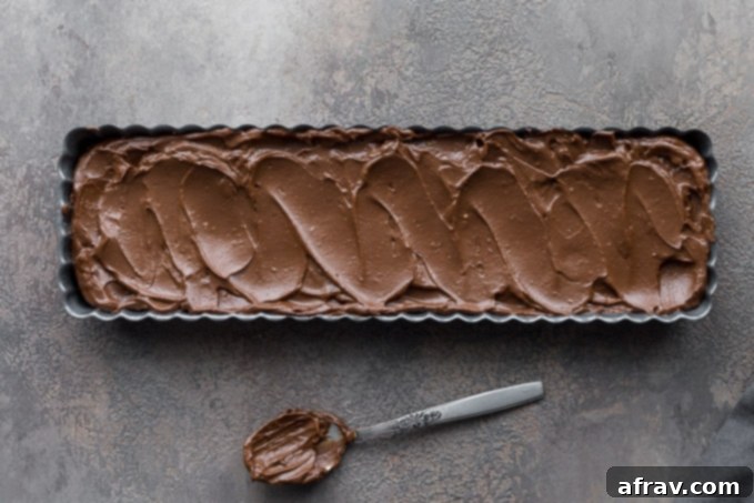 Chocolate filling spread over baked crust in tart pan.