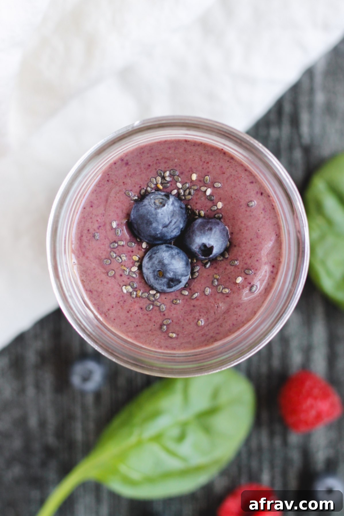 Plant-Based Berry Spinach Smoothie 6 overhead view of berry smoothie topped with blueberries and chia seeds in a glass mason jar
