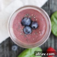 Plant-Based Berry Spinach Smoothie 7 overhead view of berry smoothie topped with blueberries and chia seeds in a glass mason jar