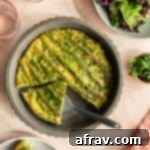 Spring Asparagus Savory Custard 2 Overhead view of a crustless asparagus quiche with slices removed and a salad off to the side.
