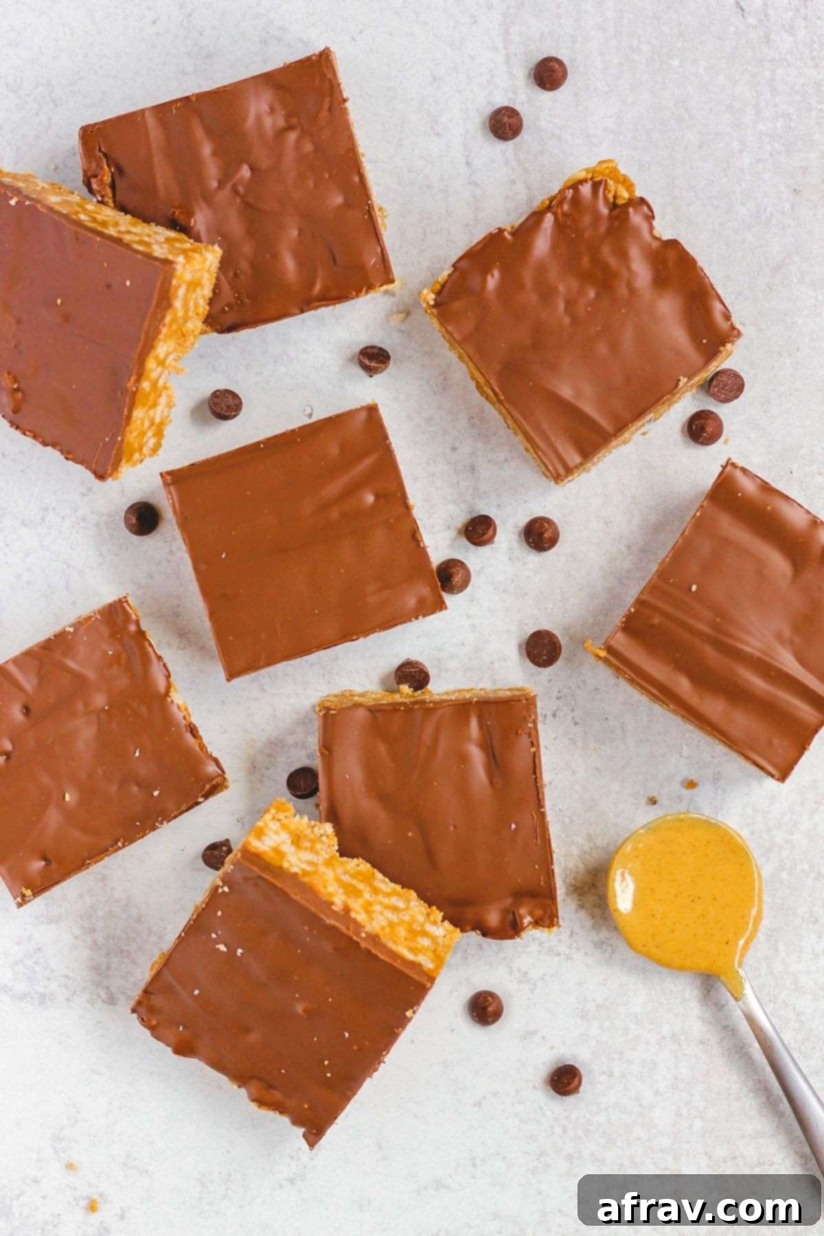 Cut up healthier scotcheroo bars on a gray surface.