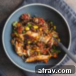 Easy One-Pan Salmon Quinoa Bake 2 Overhead view of salmon quinoa bake in a blue bowl on a grey napkin.