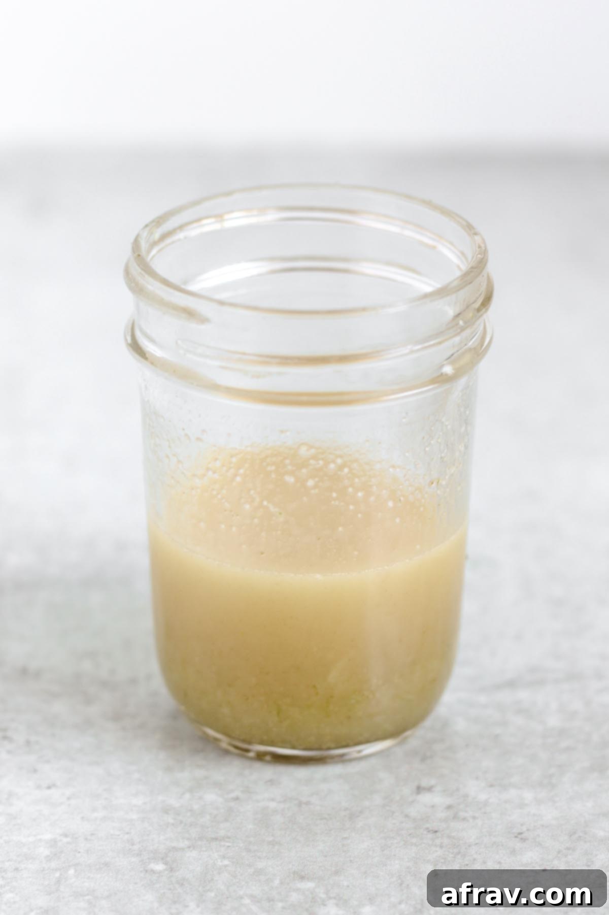 Lime vinaigrette being shaken in a mason jar, ready to dress the southwest quinoa salad.