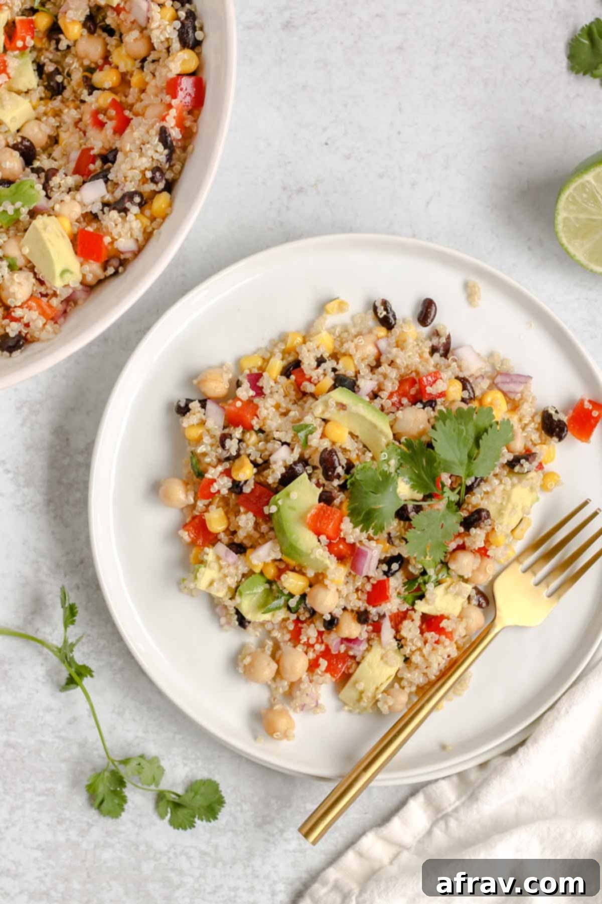 Single serving of southwest quinoa salad on a white plate with a gold fork, ready to be enjoyed.
