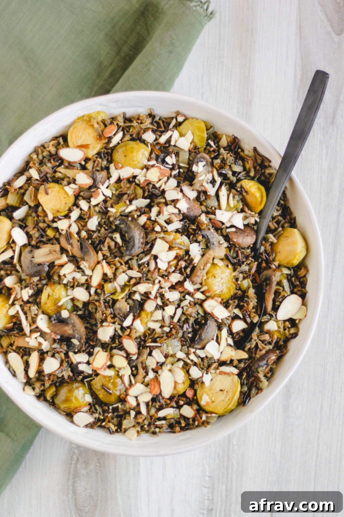 Slow-Cooked Wild Rice Delight 2 Large serving bowl of slow cooker wild rice pilaf, garnished with sliced almonds and fresh herbs, ready to be served
