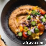 Up close view of a bowl of black bean hummus loaded with veggie toppings, a perfect and healthy vegan meal.