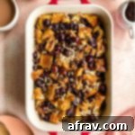 Overhead view of baked french toast casserole in a baking dish on a pink surface.