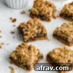 Healthy date squares arranged on a sheet of wax paper. A close-up of a stack of healthy date squares on wax paper, showing the dense, chewy texture and golden crumble.