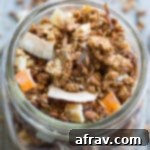 Overhead view of Coconut Cashew Crunch Grain-Free Granola in a glass jar, perfectly showing its texture and golden clusters.