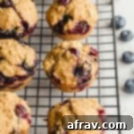 Healthy Blueberry Oatmeal Muffins cooling on a black wire rack, ready to be enjoyed.