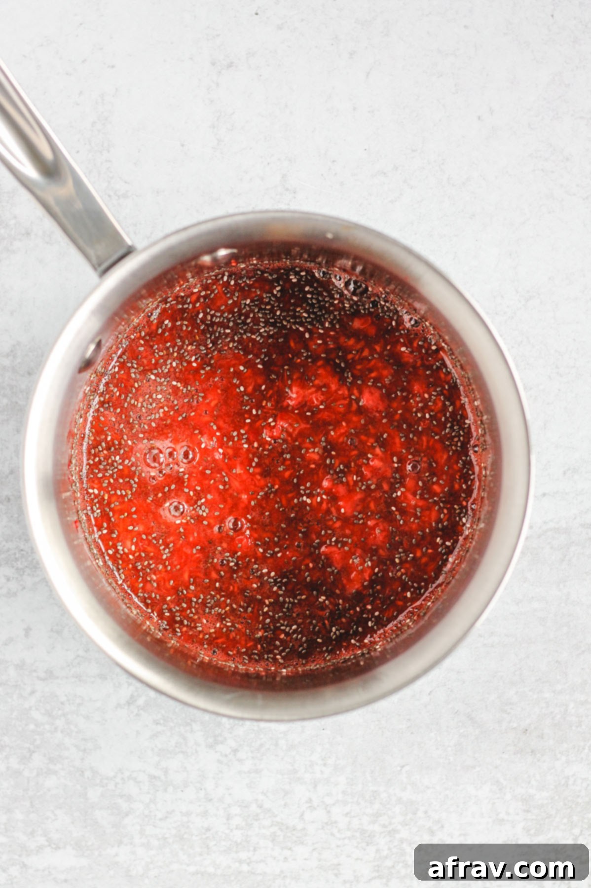 sauce pan with mashed strawberries, raspberries, and chia seeds