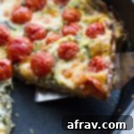 Caprese-Inspired Quiche 2 Up-close view of a slice of Tomato, Arugula and Mozzarella Quiche in a cast iron pan.