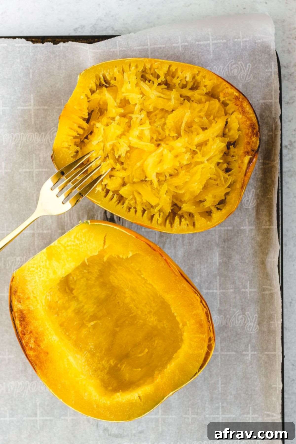 Spaghetti Squash Boats 5 Two halves of a spaghetti squash cooked with one half shredded with a fork to show "spaghetti noodles."