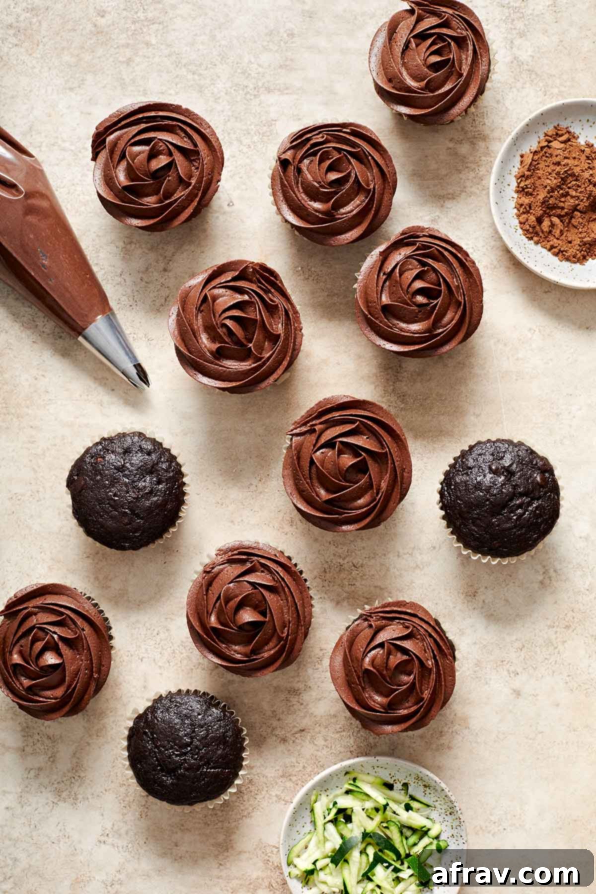Irresistibly Moist Chocolate Zucchini Cupcakes 7 A close-up of a chocolate zucchini cupcake being carefully topped with a swirl of rich chocolate frosting.
