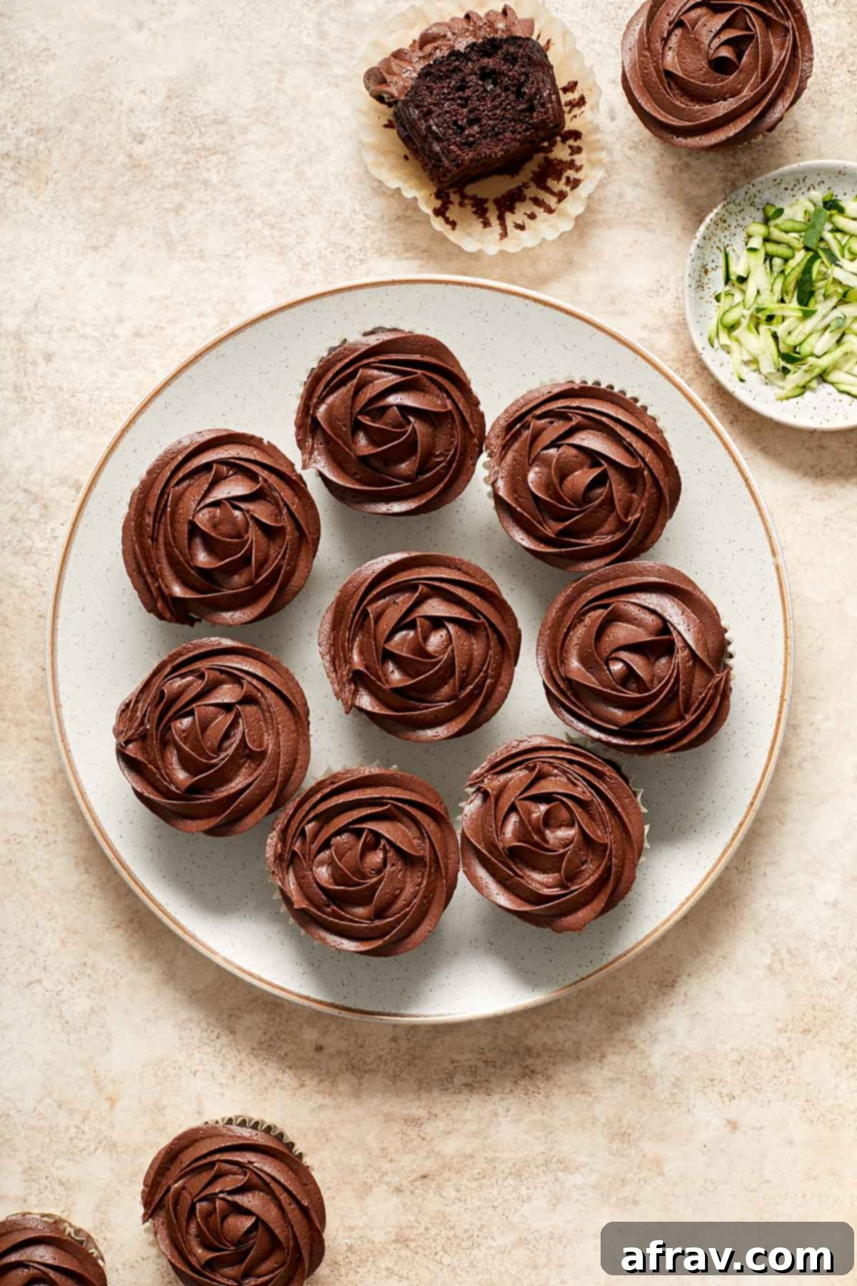 Irresistibly Moist Chocolate Zucchini Cupcakes 8 An inviting overhead shot of delicious chocolate zucchini cupcakes arranged on a plate, some topped with luscious chocolate frosting, ready to be enjoyed.