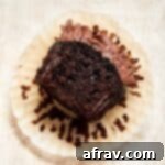 Irresistibly Moist Chocolate Zucchini Cupcakes 9 Close up view of a chocolate zucchini cupcake with a bite taken out of it.
