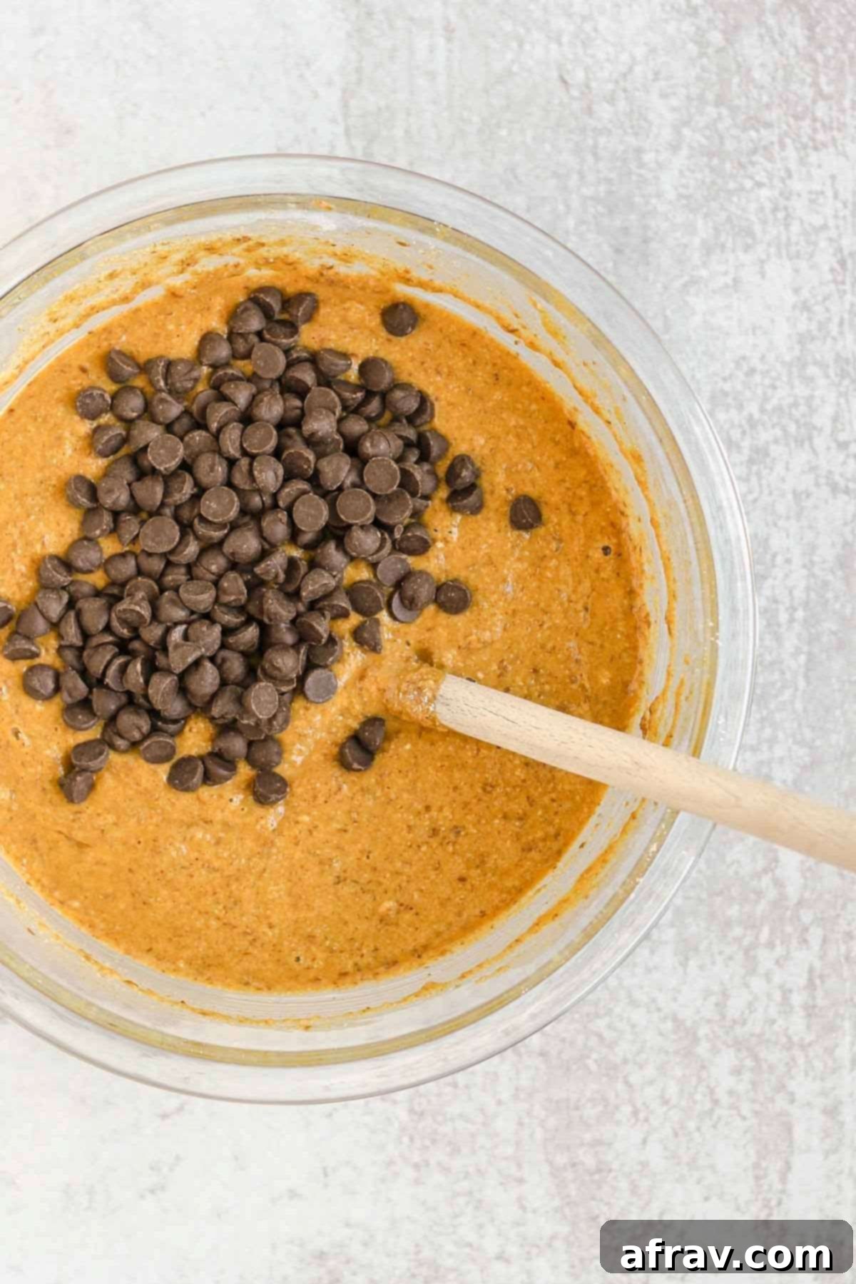 Irresistible Gluten Free Chocolate Chip Pumpkin Bread 7 Glass mixing bowl with pumpkin bread batter and chocolate chips folded in.