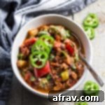 A bowl of Instant Pot Spicy Vegan Chili, ready to be served, showcasing its rich texture and vibrant colors.