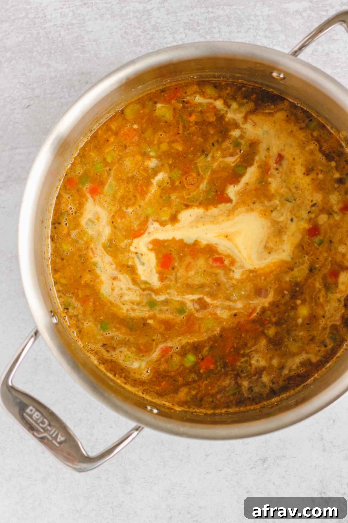 The chili base with pureed corn being stirred in, creating a rich and creamy texture.