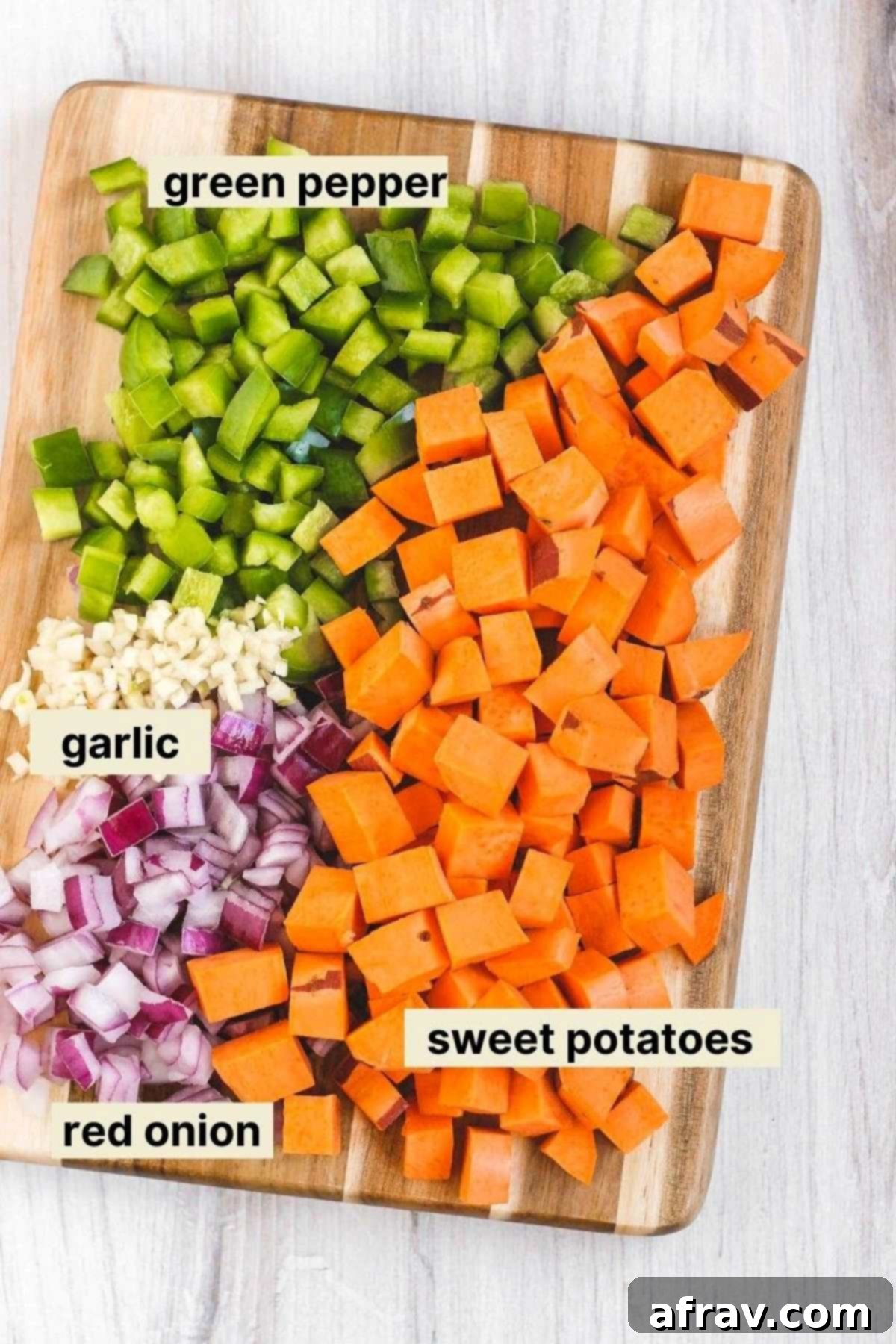 Hearty Vegan Sweet Potato Chili 4 Chopped veggies and garlic on a cutting board with labels next to each food item.