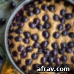 Overhead view of Rosemary Grape Ricotta Cake in a springform pan.