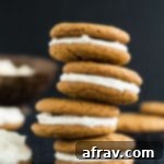 Side view of four Chewy Ginger Cookies with Lemon Cream Cheese Frosting stacked on top of each other, ready to be enjoyed.