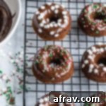 Overhead view of Mini Gingerbread Protein Donuts with Chocolate Glaze on a wire rack.