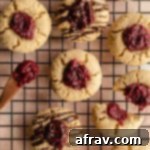Cranberry thumbprint cookies arranged on a wire rack.