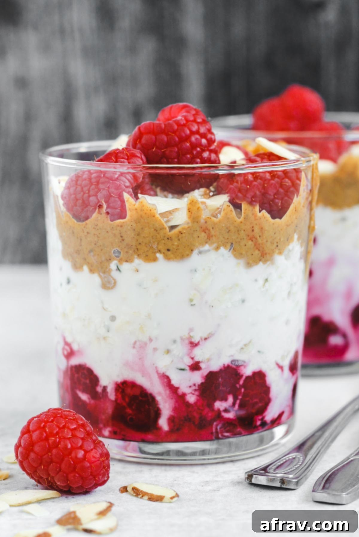 Dreamy Raspberry Overnight Oats 2 glass filled with layers of raspberries, overnight oats, and almond butter