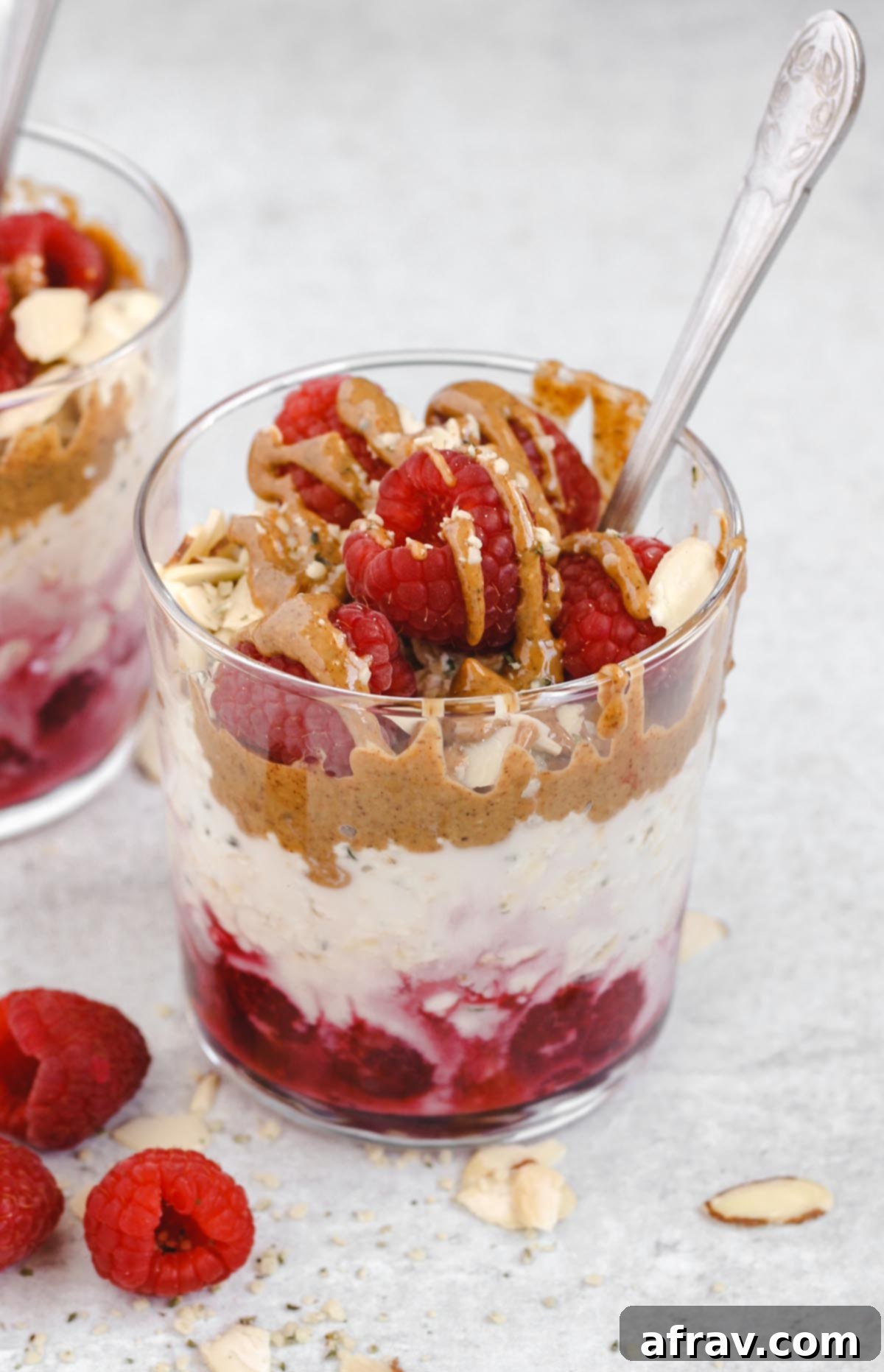 one glass of raspberry almond overnight oats with almond butter drizzled on top