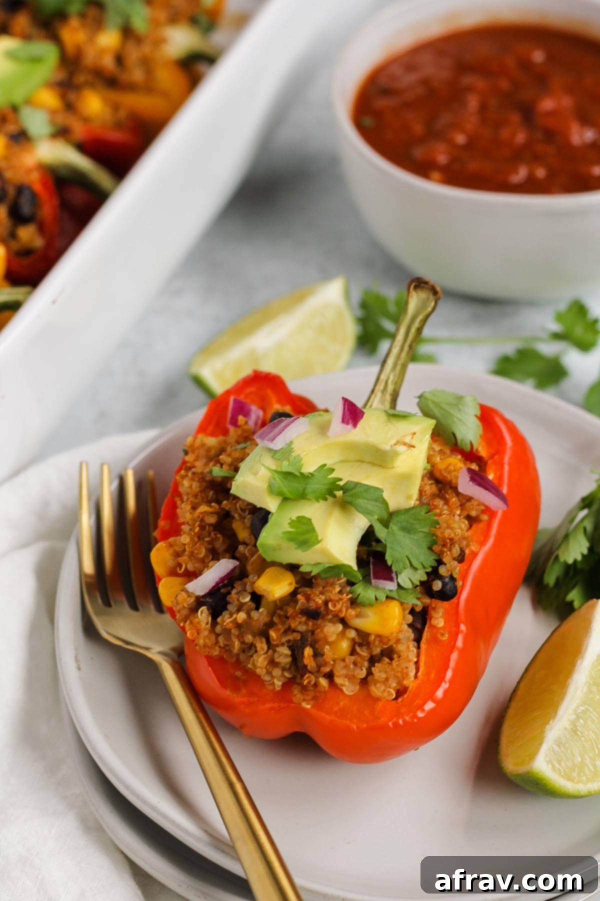 single stuffed bell pepper topped with avocado, cilantro, and onion