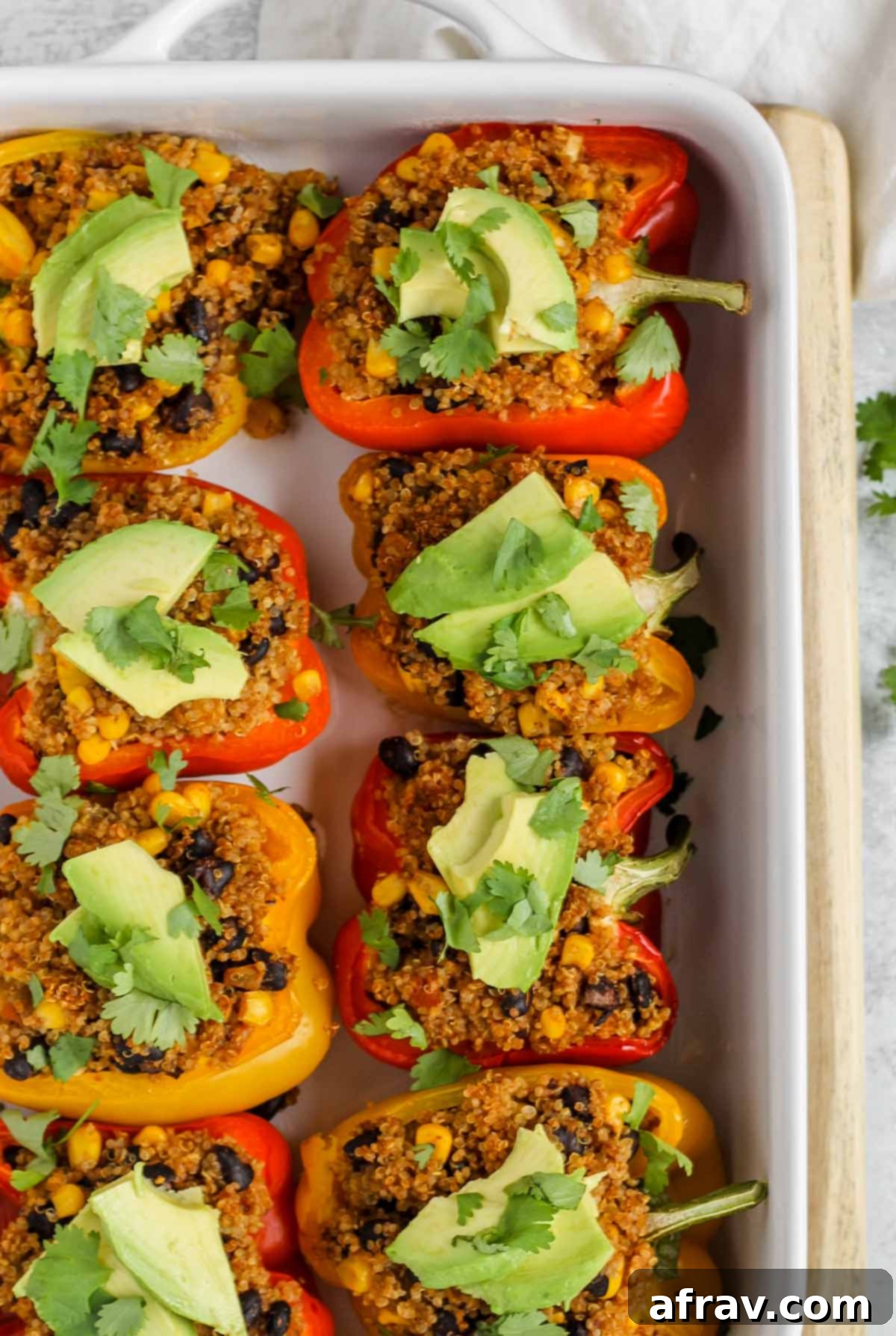 cooked stuffed vegetarian stuffed peppers topped with avocado and cilantro