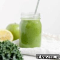 A top-down view of a glass of Apple Kiwi Kale Smoothie, highlighting its vibrant green color and refreshing appeal.