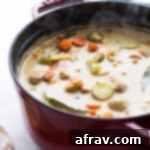 Dairy-Free Seafood Chowder in a red pot with steam rising up.
