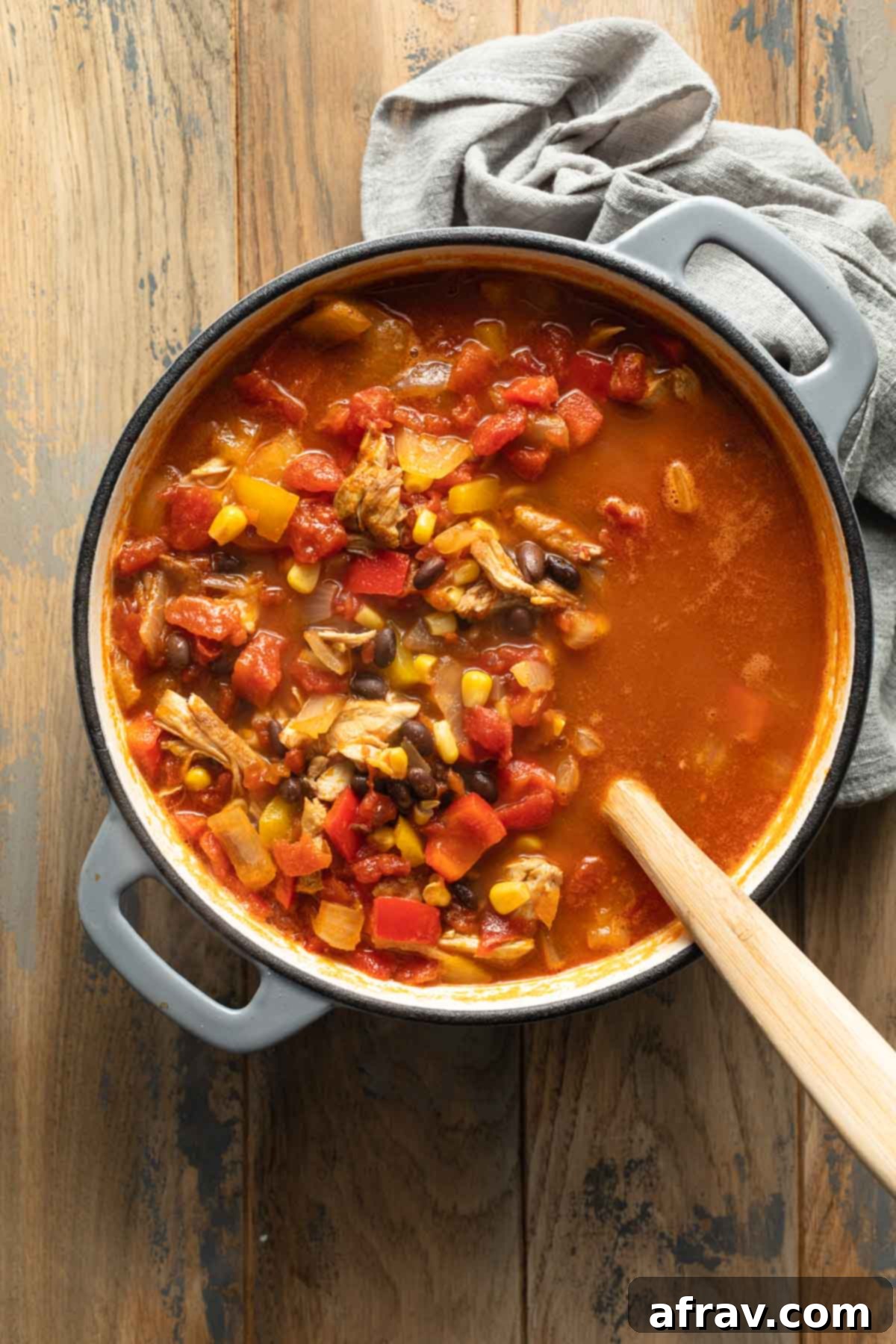 Fajita soup in a large pot with a wooden spoon inserted into it.