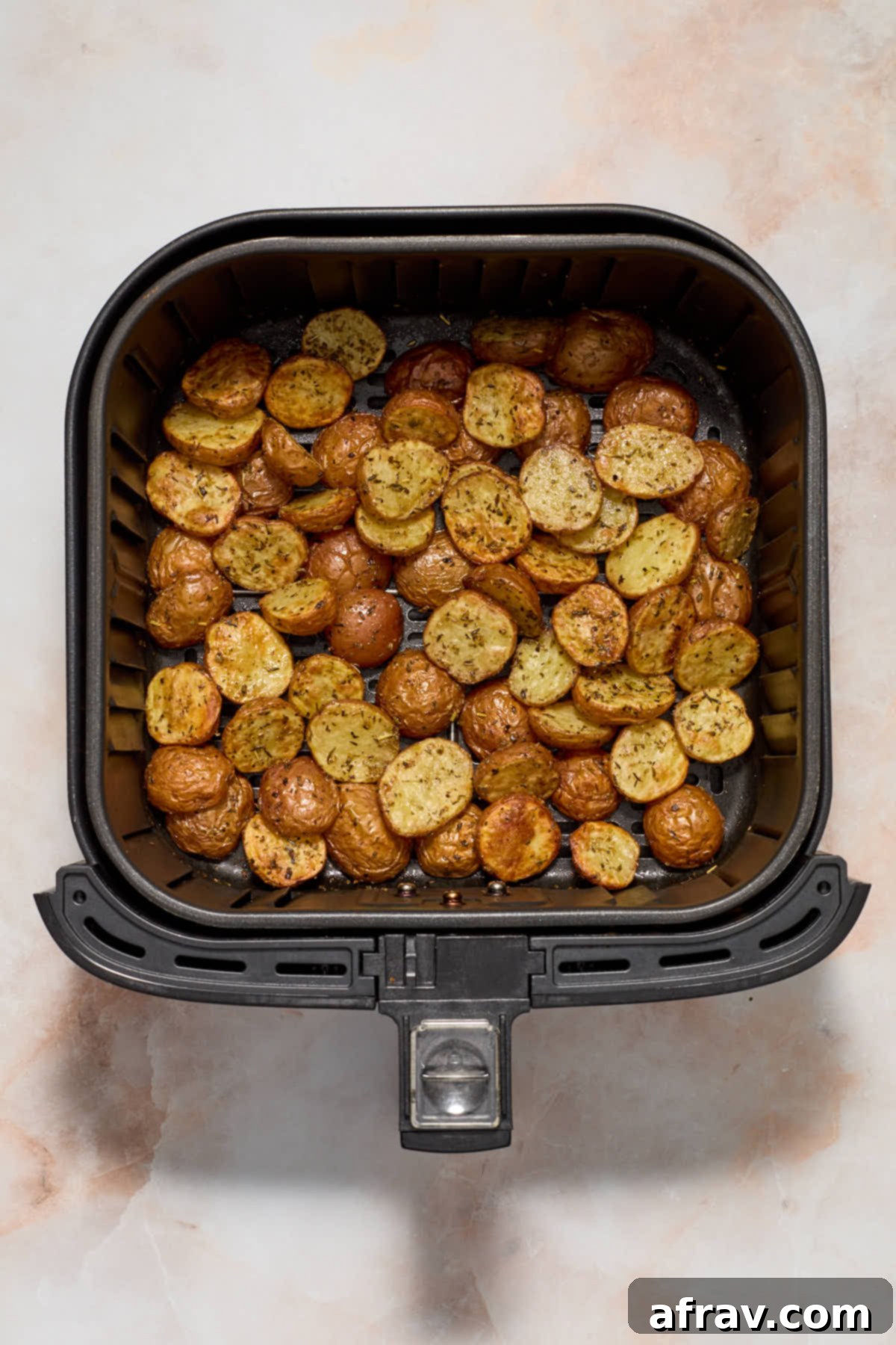 Air fried baby potatoes in the air fryer basket.