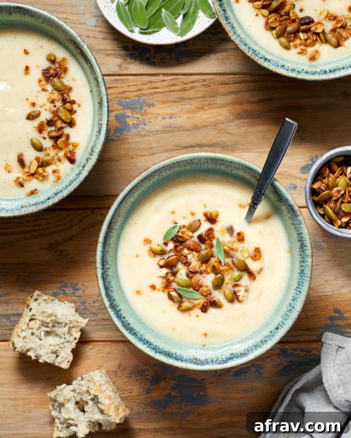 Parsnip and pear soup in green bowls with savoury granola on top.