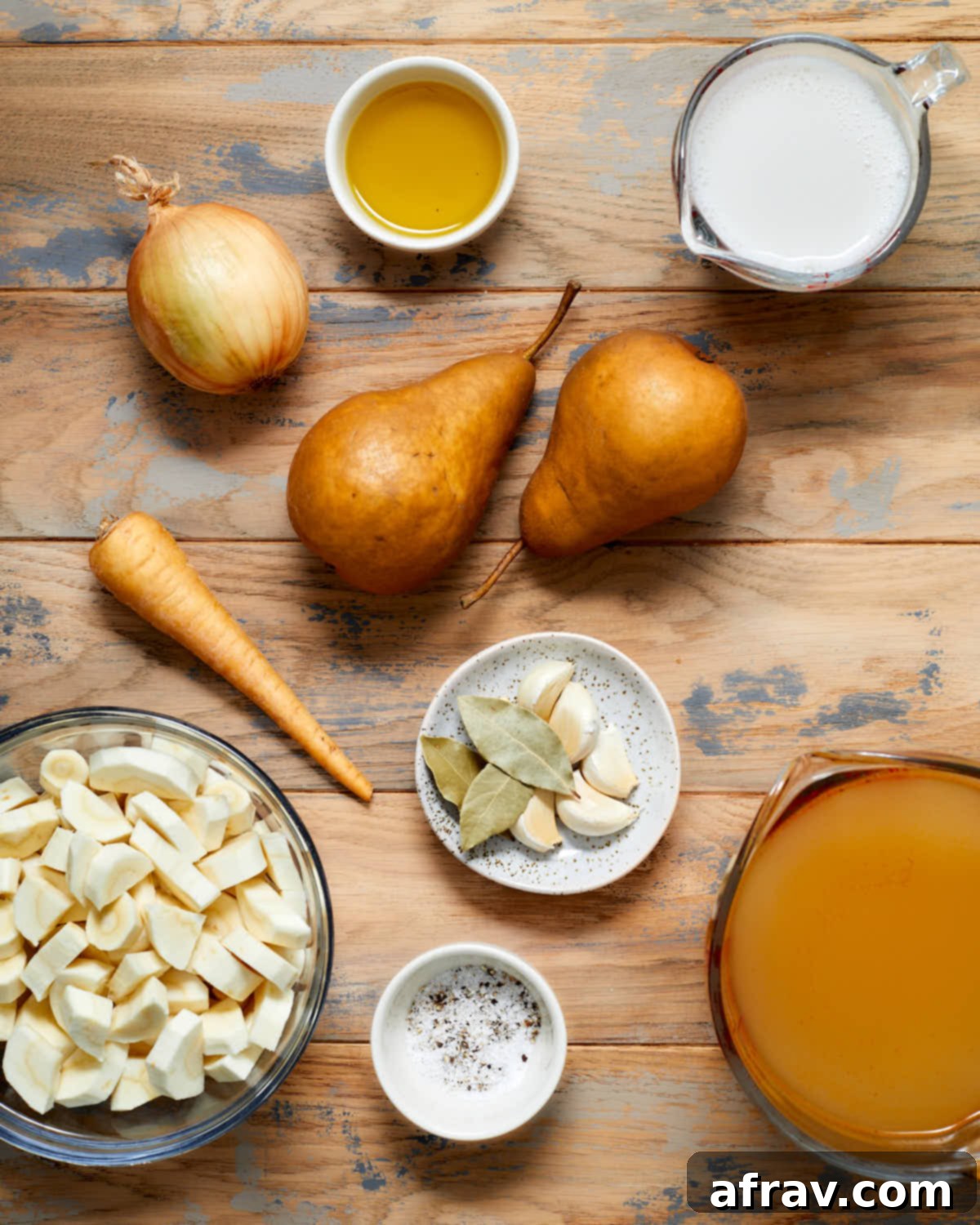 Ingredients to make parsnip pear soup arranged individually on a wooden table.