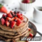 Stack of Strawberry Chocolate Chip Buckwheat Pancakes on a grey plate.