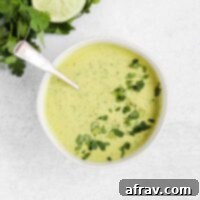 A small bowl of creamy cilantro lime dressing with a spoon.